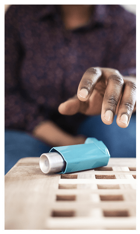 A woman reaching for an inhaler.